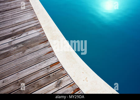 Vue rapprochée de minimaliste, une piscine et le parquet en bois composite de son deck. Maison de vacances et de détente. Banque D'Images