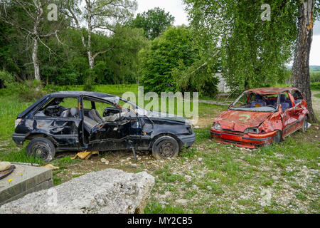 Épaves de voitures displyed sur le champ dans un camp d'entraînement militaire, Chambaran, France Banque D'Images