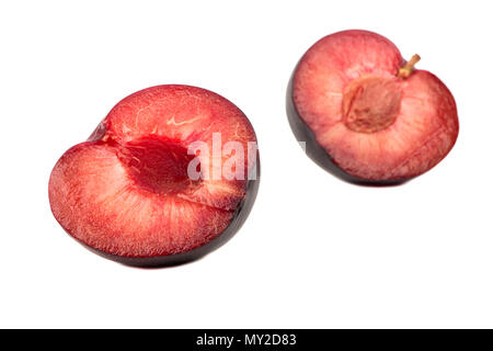 Deux moitiés de juteuses de prune rouge frais isolé sur fond blanc Banque D'Images
