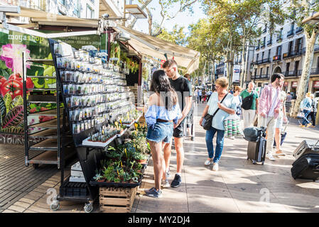 Barcelone, Espagne - 20 septembre 2017 : les touristes de prendre leurs bagages ainsi que les Ramblas tandis qu'un jeune couple choisit un cadeau à Barcelone, Catalogne, Sp Banque D'Images