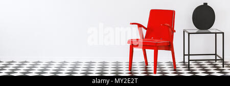 Fauteuil rouge debout dans la salle blanche avec intérieur plancher linoléum damier avec place pour votre canapé Banque D'Images