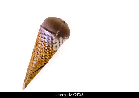 Crème glacée à la vanille avec de la confiture de canneberges dans un cône de sucre trempé dans du chocolat noir sur blanc fond isolé.rafraîchir en été.copie espace droit. Banque D'Images
