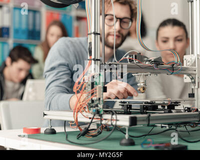 Les étudiants en génie des hommes et des femmes à l'aide d'une imprimante 3D dans le laboratoire, l'apprentissage et à la technologie concept Banque D'Images