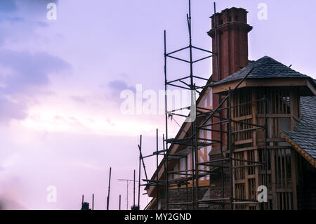 En construction bâtiment avec toit en pente, avec une cheminée et une tour de construction frame shot contre un ciel nuageux coucher du soleil dans l'hillstation de Shimla Banque D'Images