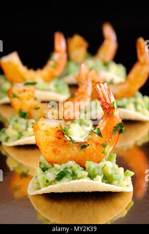 Collation de chips de remplissage avec de l'avocat et crevettes sautées aux herbes aromatisées. Banque D'Images