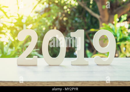 Nouveau concept : année 2019 nombre en bois pour le nouvel an sur table en bois avec du soleil. Banque D'Images