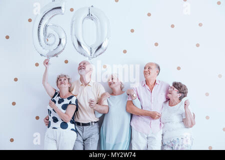 Grand-mère et grand-père avec des ballons argent célébrant 60 ans Banque D'Images