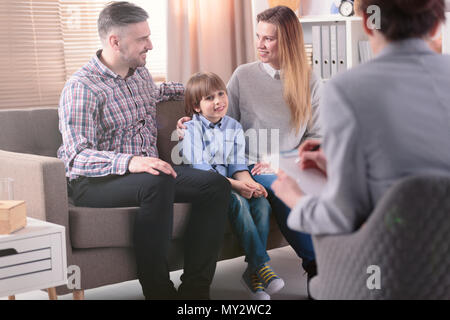 Vue arrière à aider les jeunes femmes psychothérapeute famille avec un enfant à résoudre des problèmes dans la relation. Famille heureuse dans l'arrière-plan Banque D'Images