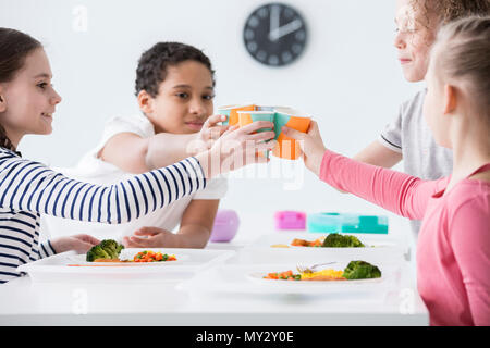 Des enfants heureux de faire un toast au cours de l'anniversaire d'un ami à la maison Banque D'Images