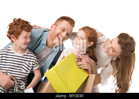 Famille heureuse avec deux enfants holding shopping bags isolated on white Banque D'Images