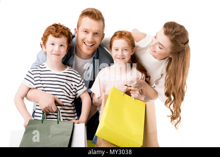 Young family holding shopping bags and smiling at camera isolated on white Banque D'Images