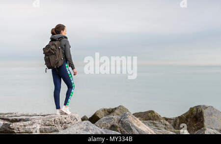 Randonneur femme debout sur des roches portant un sac à dos Banque D'Images