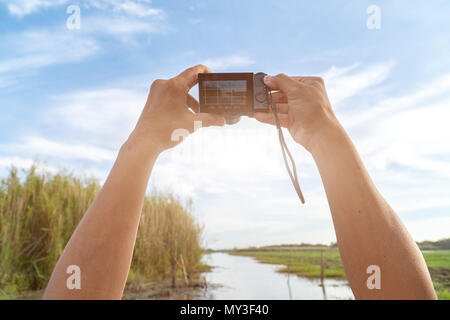 Photographie de voyages en plein air,mains tenir l'appareil photo et prendre de belles photos.Accessoires de voyage objet. Banque D'Images