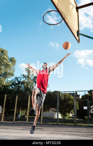 Joueur de basket-ball américain africain lancer ballon dans panier pendant le jeu Banque D'Images