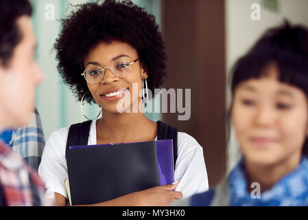 Female college student smiling in corridor Banque D'Images