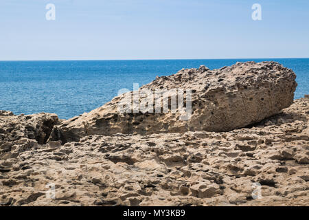 La surface de la structure de la roche, rappelant une terre de lune. Gros rocher sur le bord de mer. Horizon de la mer Méditerranée avec de petites vagues. Ciel bleu. Gozo, l'île Banque D'Images