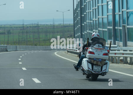 Région de Krasnodar, Russie - le 19 mai 2018 : Le cavalier blanc sur les courses de moto sur l'autoroute vers le pont de Crimée. Banque D'Images