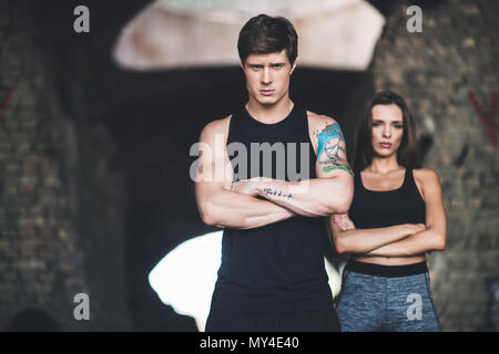 Portrait de l'homme et la femme à sportswear with arms crossed looking at camera Banque D'Images