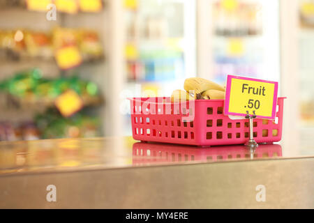 Cantine de l'école tuck shop cafétéria vendant des fruits sains : options pour les étudiants. les bananes dans un bac en acier inoxydable rouge sur le banc en premier plan Banque D'Images