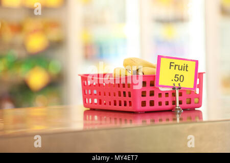 Cantine de l'école tuck shop cafétéria vendant des fruits sains : options pour les étudiants. les bananes dans un bac en acier inoxydable rouge sur le banc en premier plan Banque D'Images