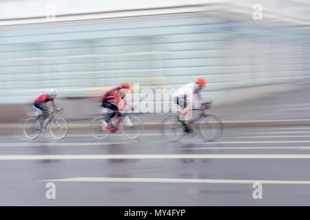 Silhouettes de trois jeunes cyclistes sur route de la ville, le jour, l'abstrait arrière-plan flou, copy space Banque D'Images