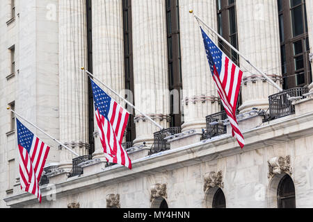 Brandissant des drapeaux américains sur l'extérieur de la Bourse de New York, Wall street, lower Manhattan, New York City, USA. Banque D'Images