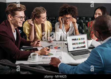 Groupe de collègues d'affaires doing paperwork ensemble dans cafe Banque D'Images