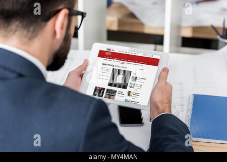 Businessman holding tablet chargé avec bbc news page Banque D'Images