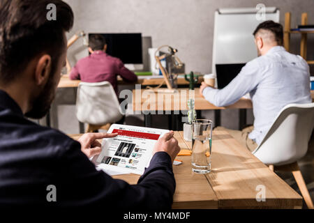 Businessman holding tablet chargé avec bbc news page Banque D'Images