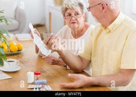 Senior woman reading notice d'un médicament et personnes âgées man holding pills Banque D'Images