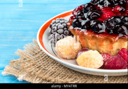 Tarte aux fruits sur une plaque avec des baies congelées sur limogeage close-up Banque D'Images