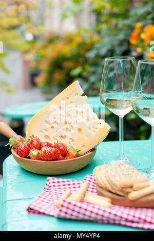 Fromage et fraises. Deux verres de vin blanc. Une table avec un en-cas à un parti. Jours fériés . Place pour le texte. Banque D'Images