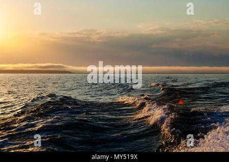 Coucher du soleil met en lumière un service bateaux vagues avec des couleurs d'or sur le lac Supérieur et les Îles Apostle National Lakeshore, Bayfield, Wisconsin, États-Unis Banque D'Images