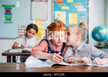 Magnifiques petites filles potiner dans la classe Banque D'Images