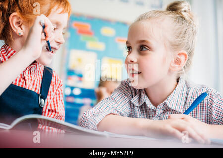 Magnifiques petites filles potiner dans la classe Banque D'Images