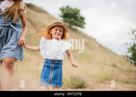 Cropped shot of mother and daughter holding hands on grassy hill Banque D'Images