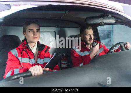 Les jeunes hommes et les femmes assis dans les ambulanciers ambulance Banque D'Images
