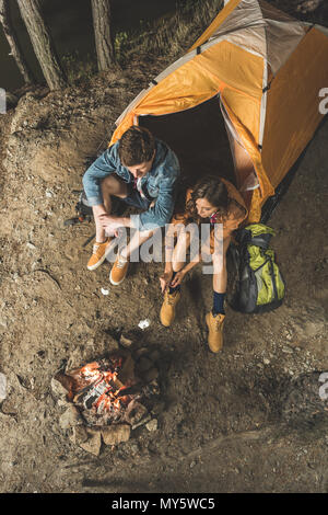 Vue de dessus de la torréfaction de couple sur des bâtons de guimauve en voyage de camping Banque D'Images