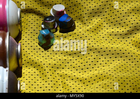 Plusieurs bouchons pour les pulvérisateurs de peinture aérosols utilisés se trouvent sur la chemise de sport d'un joueur de basket-ball fait de polyester Tissu. Le concept de la jeunesse l'art de la rue, Banque D'Images