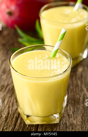 Mangue smoothie rafraîchissant et yaourt dans des verres avec paille (Selective Focus Focus, un tiers dans le premier verre) Banque D'Images