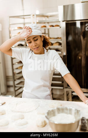 Femelle surchargés de sueur essuyage baker front à la fabrication Banque D'Images