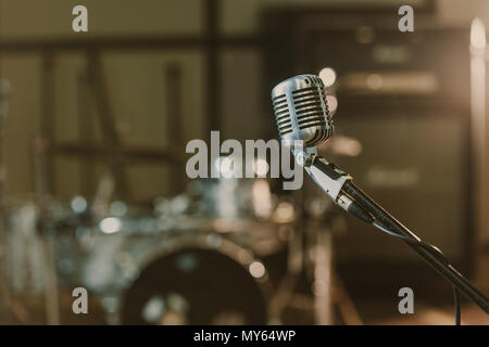 Close-up shot of vintage microphone en position contre un ensemble de batterie floue Banque D'Images