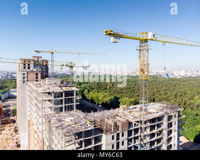 Vue aérienne du site de construction avec grue jaune et multi étages bâtiment résidentiel Banque D'Images