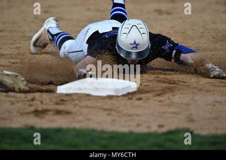 Base Runner plongée sous-marine en toute sécurité au premier base au cours d'une tentative d'arracher. USA. Banque D'Images