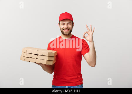 Concept de livraison : livraison de pizza man making OK S'identifier plus isolé sur fond gris. Banque D'Images