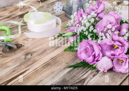 Fleuriste en milieu de travail. Fleurs et accessoires pour fabriquer des bouquets sur un fond de bois Banque D'Images