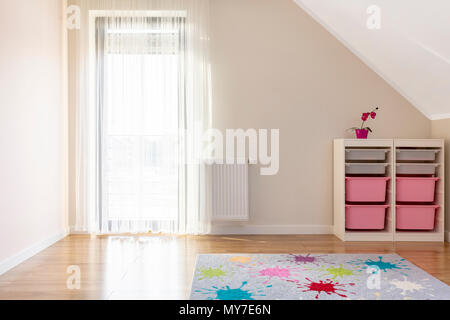 Tapis coloré à motifs en salle de jeu intérieur avec étagères et fenêtre. Photo réelle Banque D'Images