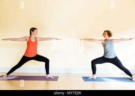 Deux femmes pratiquant deux guerrier (virabhadrasana II) yoga pose in yoga studio Banque D'Images