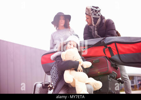 Fille avec parents équitation sur chariot à bagages Banque D'Images