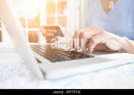 Portrait of woman holding credit card using laptop Banque D'Images